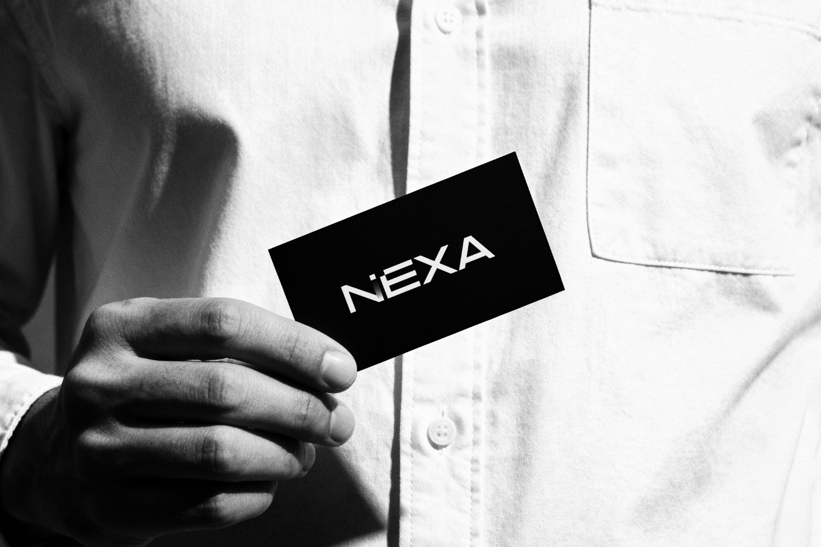 Biglietto da visita NEXA tenuto in mano